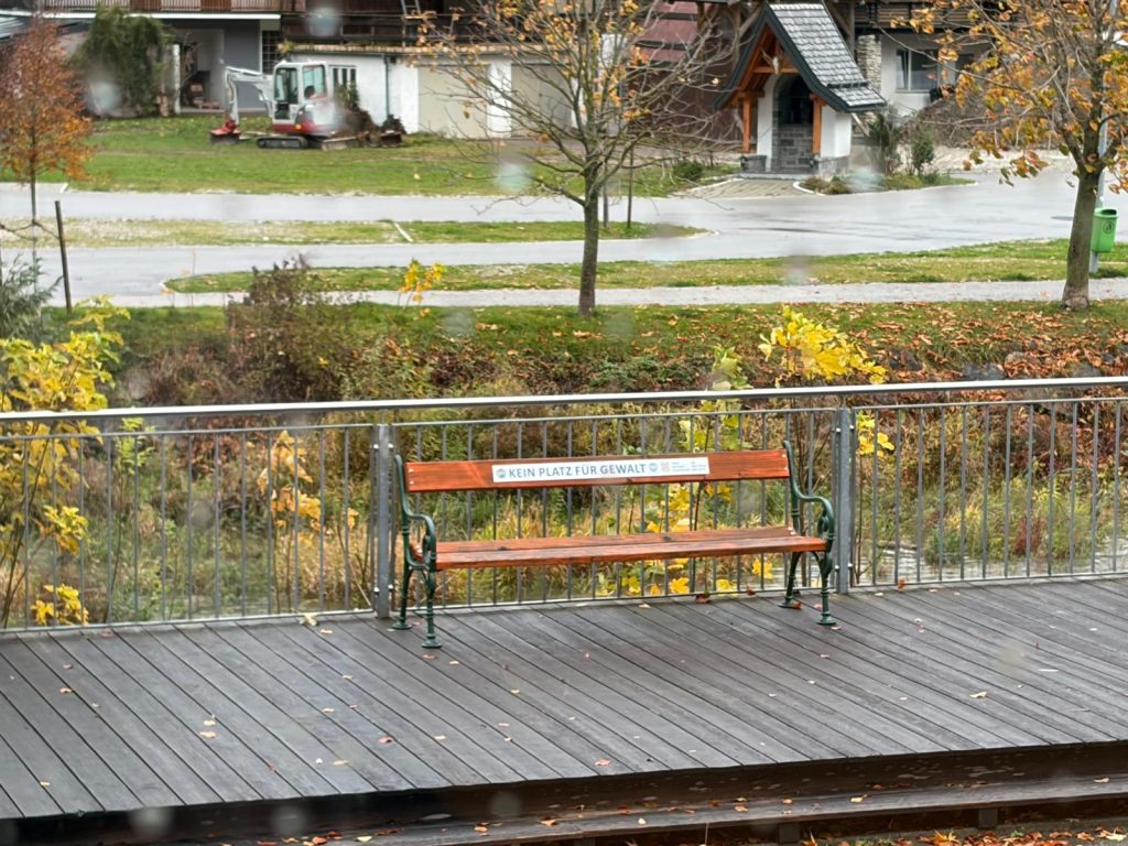 Eine orange Bank steht auf einem Weg.