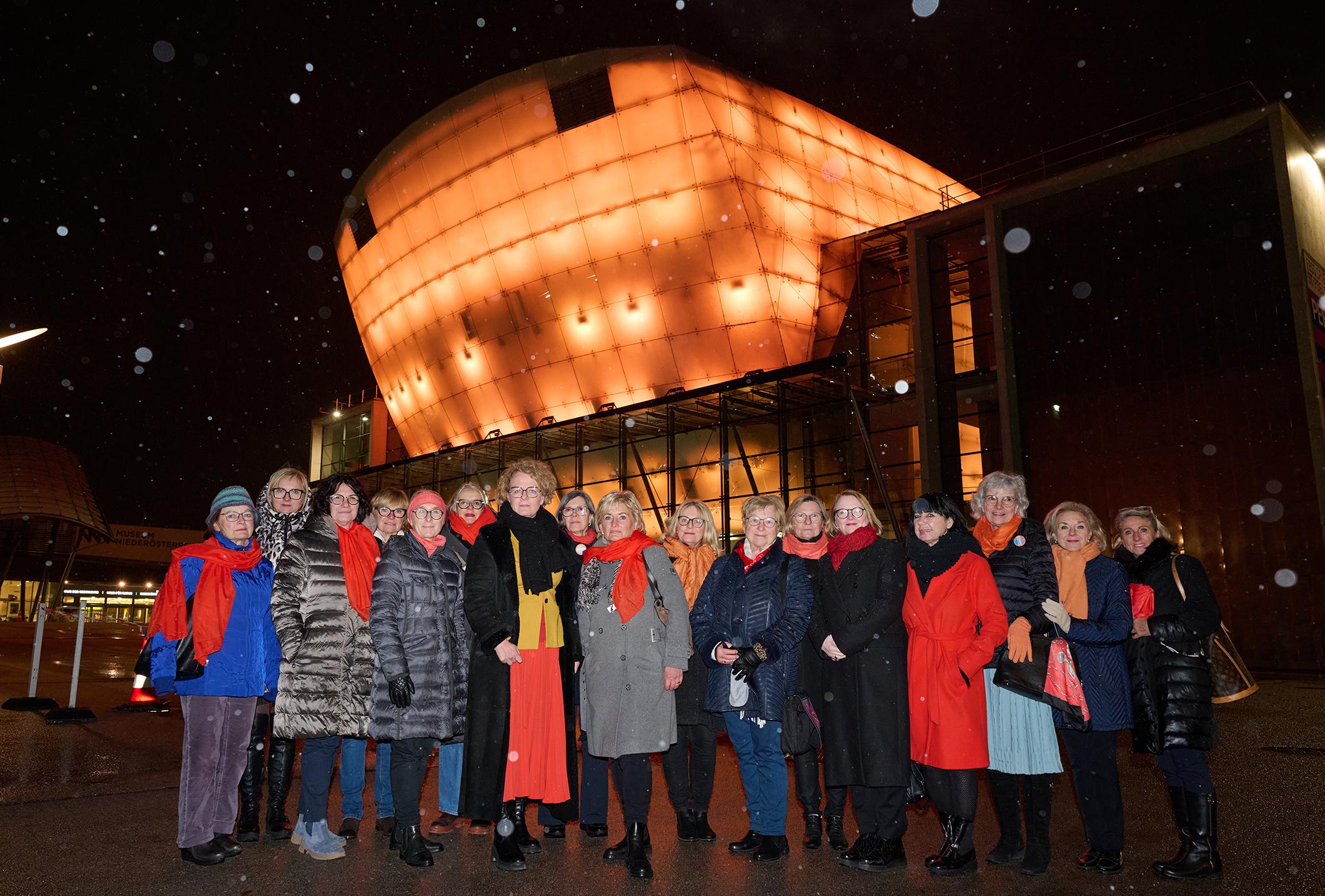 Soroptimistinnen, gemeinsam mit Landesrätin vor dem orange beleuchteten Fstspielhaus. Foto: NLK Pfeiffer